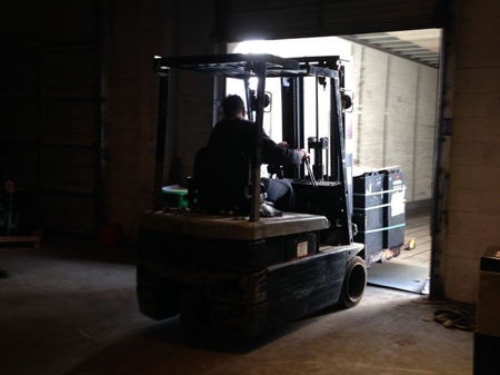 Loading forklift batteries on the scrap truck.